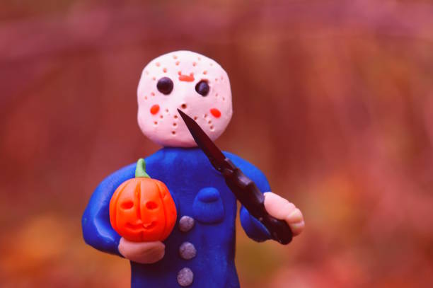 toy jason in a hockey mask and a pumpkin in his hand threatens with a knife. - friday the 13th imagens e fotografias de stock