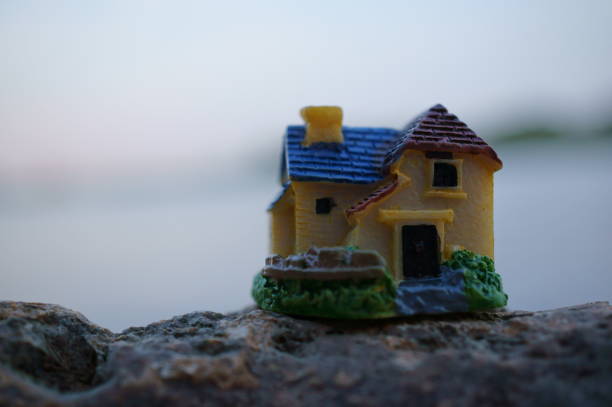 istock A toy house on the river bank. 1607044180
