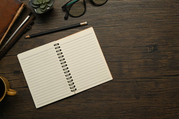 istock Blank notebook, pen and wireless keyboard on wooden table. Flat lay, top view with copy space 1607050238