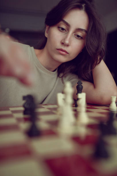 istock Expert Female Chess Player Devising Check Mate In Three Moves 1607052500