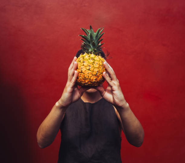 istock Pineapple woman with a red wall 1607078495