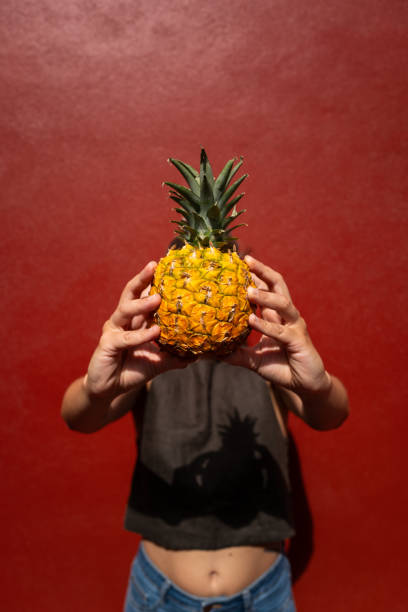 istock Pineapple woman with a red wall 1607078502