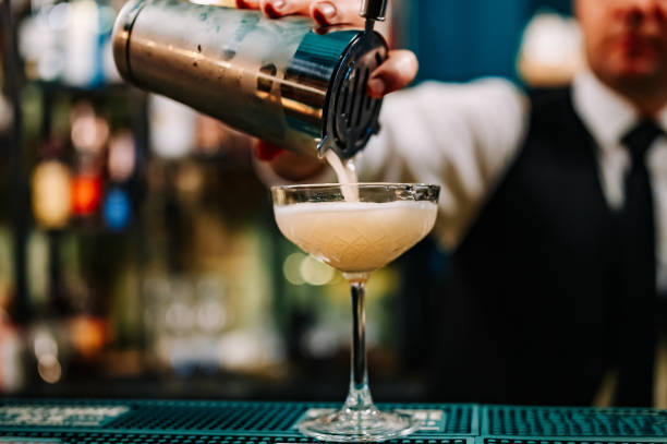 homme barman à main faisant un cocktail en verre sur le comptoir du bar - Photo