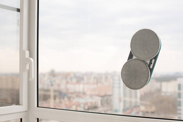 istock Smart vacuum cleaner washing windows. Home appliance concept 1607089569