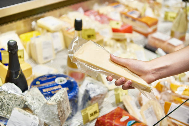 Plastic packaging with hard cheese in store stock photo