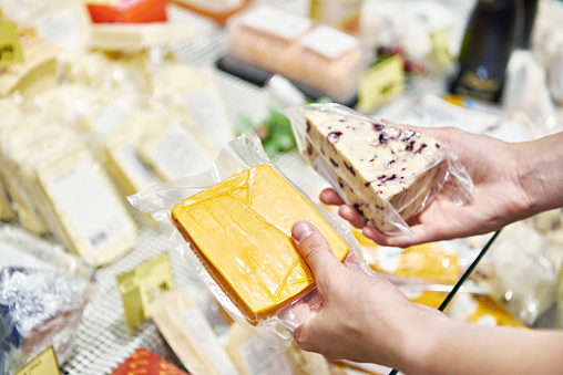 Cheeses in hands on shop