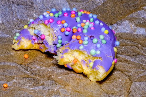 istock Bitten glazed donut with colorful sprinkles. Lying flat. Food concept. Macro concept. Sugar is bad for health. 1607103580