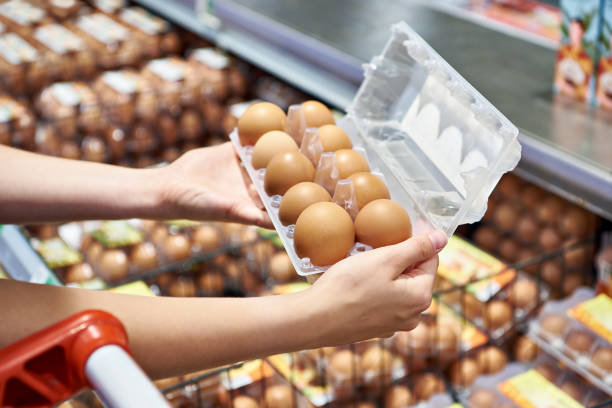 istock Woman with packing eggs in shop 1607103680