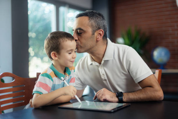 istock Father teaching his little son how to draw using digital tablet and digitized pen at home 1607107240