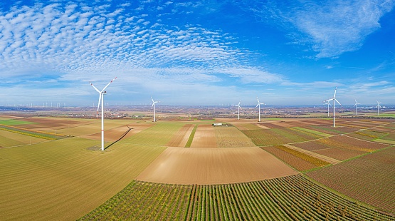 Stunning aerial panoramic view of a wind farm in Germany with a beautiful blue sky in the background