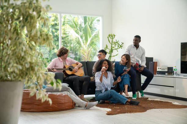 istock Group of friends playing karaoke at home. 1607178030