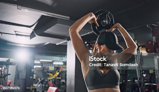 istock Sporty woman exercising on multistation at gym for arm and shoulders muscles. Fitness exercising in gym. 1607184074