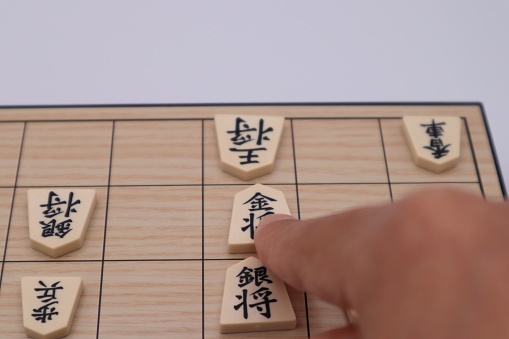 A picture of a person playing a check in shogi