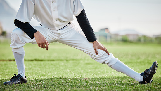 Baseball stadium, stretching legs or athlete on field ready for training match on grass in summer. Body of man, fitness workout or zoom of sports player warm up to start softball exercise outdoors