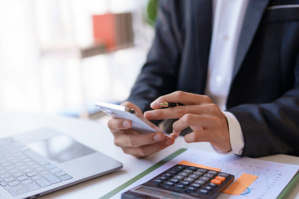 istock Businessman using smartphone to send text messages in the office. 1607229487
