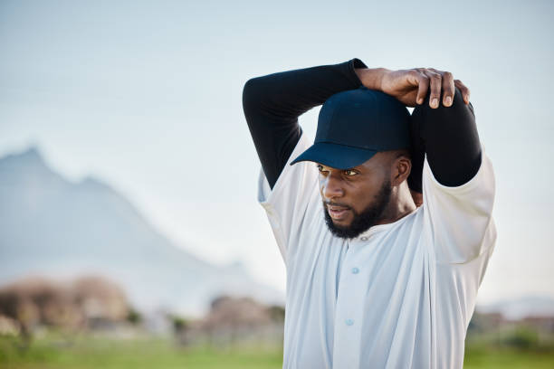 istock Baseball field, thinking or black man stretching arm in training ready for match on pitch or field in summer. Workout exercise, fitness mindset or sports player in warm up to start playing softball 1607235421