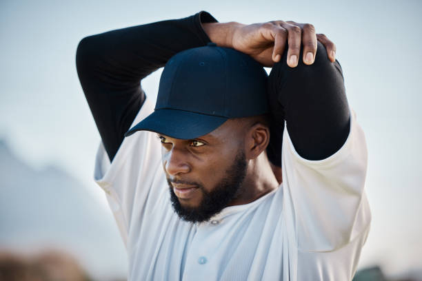 istock Baseball field, thinking or black man stretching in training ready for match in outdoor workout. Arm exercise, fitness mindset or focused young sports player in warm up to start playing softball 1607235434