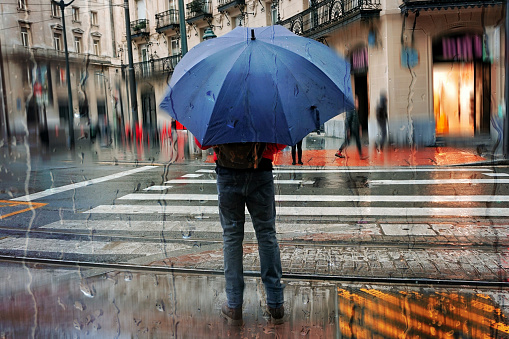 Bilbao, Vizcaya, Spain - December 4, 2023: people with an umbrella in rainy days in winter season, bilbao, basque country, spain