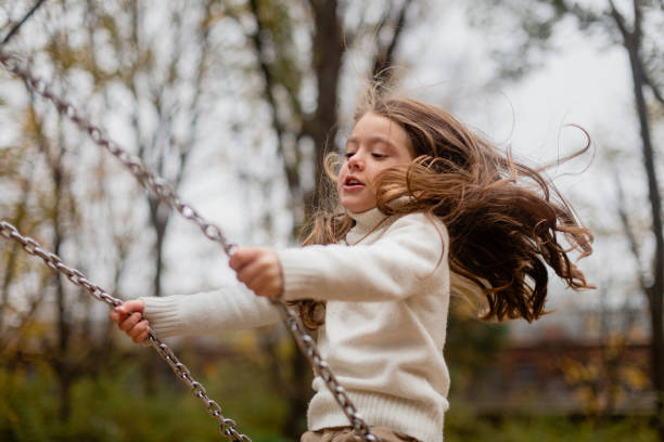 istock Girl swinging in a playground 1607247140