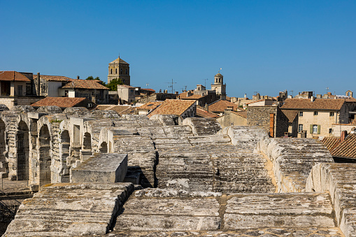 Bell tower of Saint-Trophime Cathedral and Clock Tower of Arles City Hall above the city from the arenas