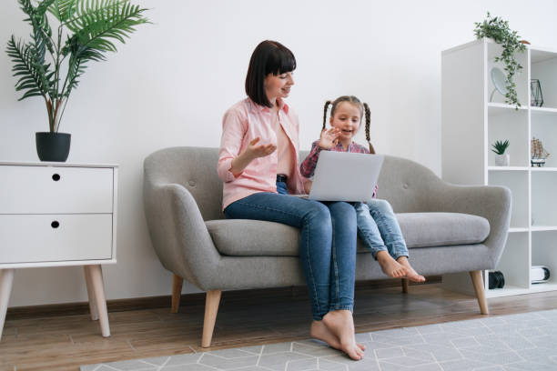 istock Ladies greeting relative during online video call via laptop 1607262747