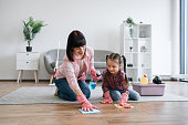 Mom rubbing laminate with cloth together with daughter