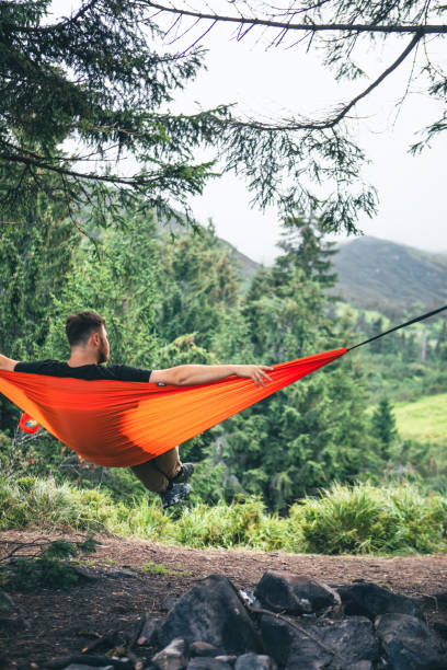 istock man in hammock at camping site mountains on background 1607316814