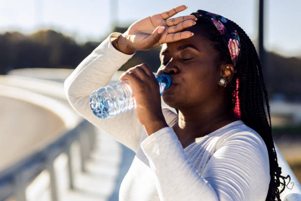 istock Young plus size women resting after running drinking water. 1607320018