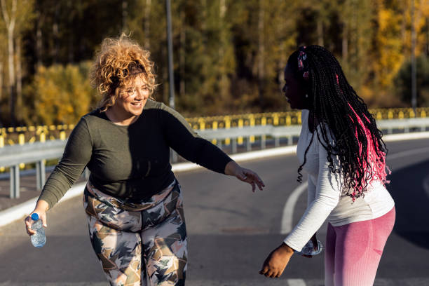 istock Two young plus size women jogging together. 1607320619