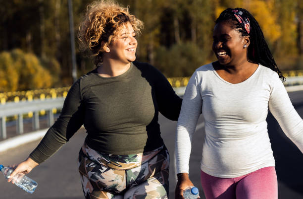 istock Two young plus size women jogging together. 1607320620