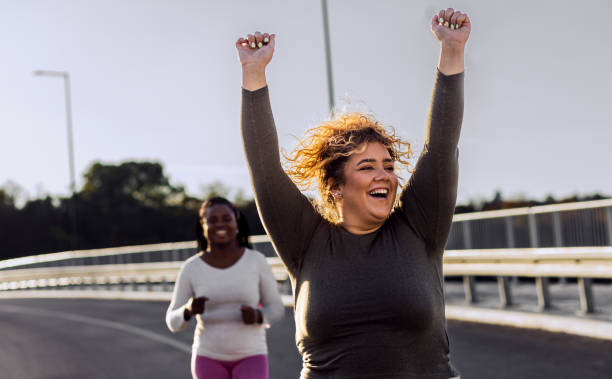 istock Two excited young plus size women jogging together. 1607321184