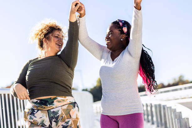 istock Two excited young plus size women jogging together. 1607321814