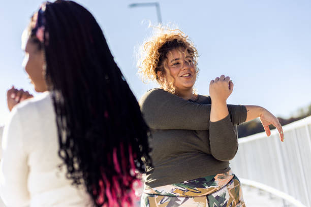 istock Two young plus size women stretching together before running. 1607321818