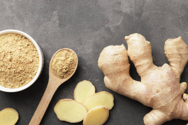 istock Composition of fresh ginger root, whole and pieces, Ground ginger in a bowl with place for text, top view. 1607322913