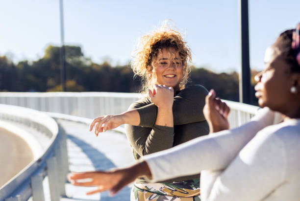 istock Two young plus size women stretching together before running. 1607323446
