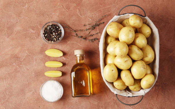 istock Composition of young potatoes, spices, butter, kitchen utensils. Cooking concept. on a colored background with place for text 1607324589