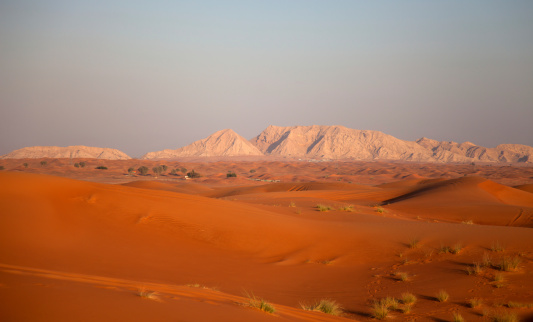 Desert sand dunes with Hatta mountains in background, Dubai, United Arab Emirates