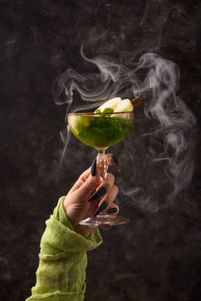 Halloween green apple cocktail with witch hand stock photo