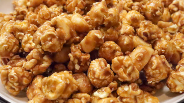 Close up of crisp caramel popcorn that is coated in a sweet, thin candy shell from heated sugar or molasses syrup. A delightful treat.