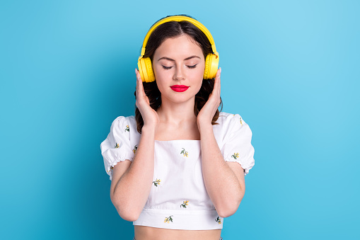 Photo of pretty adorable lady wear white blouse closed eyes enjoying songs isolated blue color background.