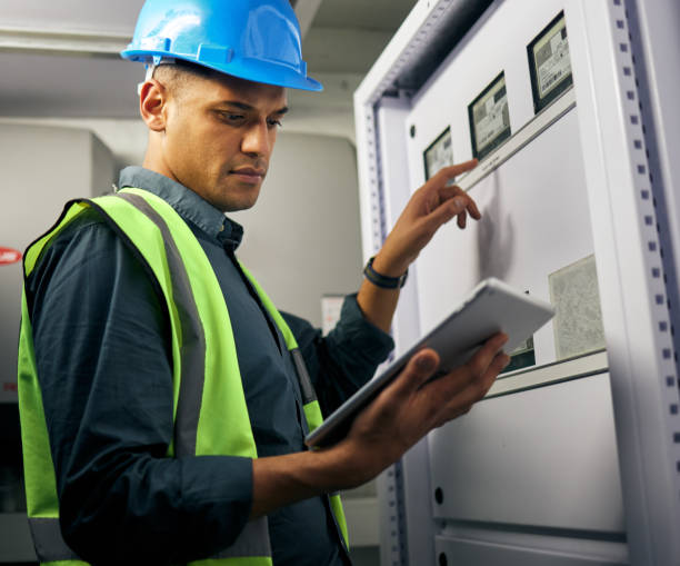 istock Electrician, engineering and tablet with man in control room for inspection, quality assurance and energy. Electricity, safety and industrial with handyman for maintenance, technician check and power 1607435656