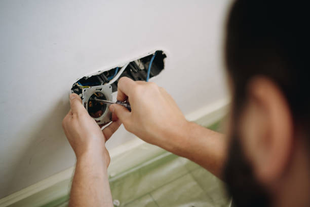 istock man installing socket. electrician hands holding screwdriver. Renovation, repair concept 1607437782
