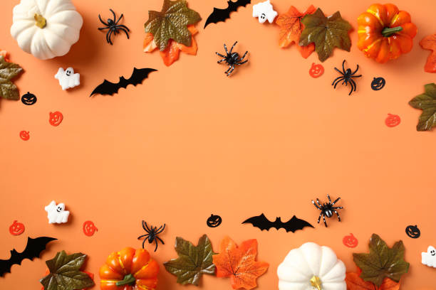 istock Happy Halloween holiday concept. Halloween decorations, pumpkins, bats, ghosts, spiders, maple leaves on orange background. Halloween party invitation card mockup. Flat lay, top view 1607451604