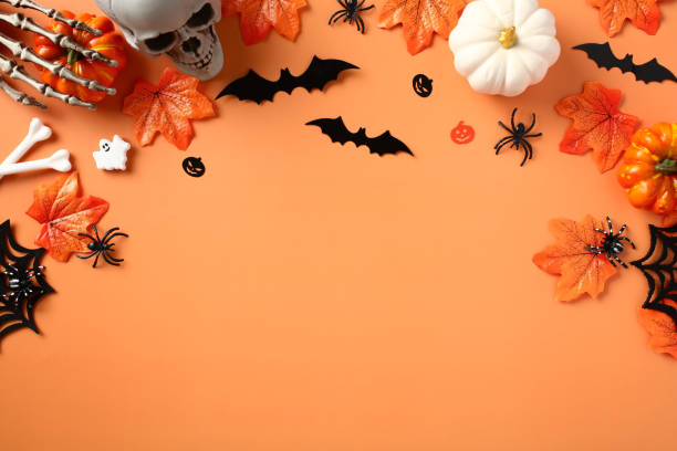 istock Happy Halloween holiday concept. Halloween decorations, spiders, pumpkins, bats, ghosts, maple leaves on orange background. Flat lay, top view, copy space. 1607454553