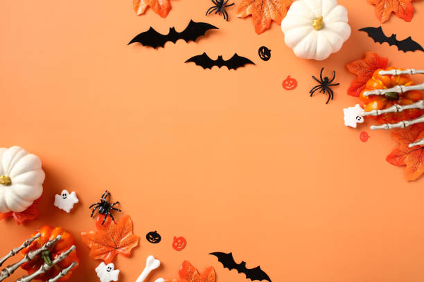 istock Halloween banner design. Flat lay pumpkins, spiders, bats, maple leaves on orange background. 1607455138