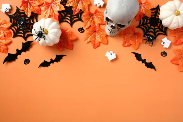 istock Halloween flat lay composition with skull, pumpkins, spiders webs, bats, ghosts, maple leaves on orange background. Happy Halloween greeting card. 1607456238