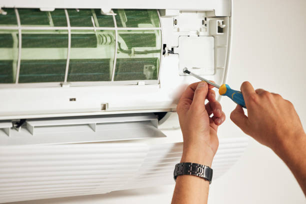 istock Maintenance, air conditioner and hands of man with screwdriver for problem solving on machine. Aircon, ac repair and handyman service with technician, electrician or contractor working on ventilation 1607468469