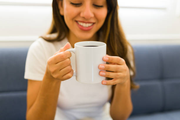 istock Happy latin woman drinking coffee in a coffee mug with copy space 1607470124
