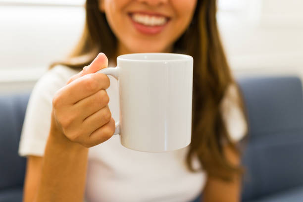 モックアップの白いコーヒーマグを飲むラテン系女性の接写 - shirt lifestyles close up cheerful ストックフォトと画像