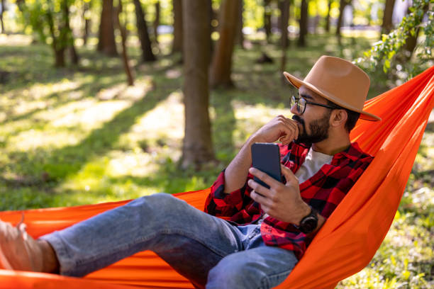 istock Bearded young man in s straw hat feeling relaxed in hammock 1607474593
